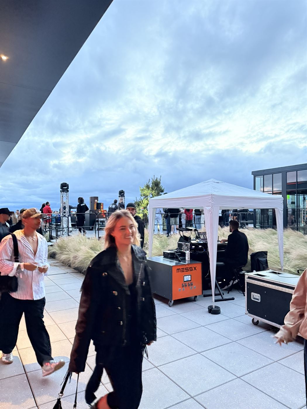 Guests at the rooftop party at dusk with the MESSX 10K running the sound system silently